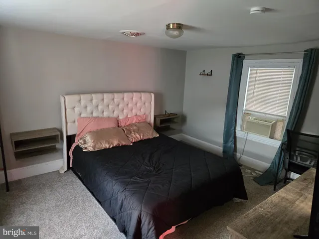 a bedroom with a bed and a flat tv screen on a dresser