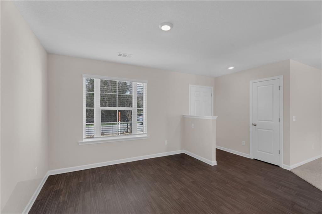 Spare room featuring dark wood finished floors and recessed lighting