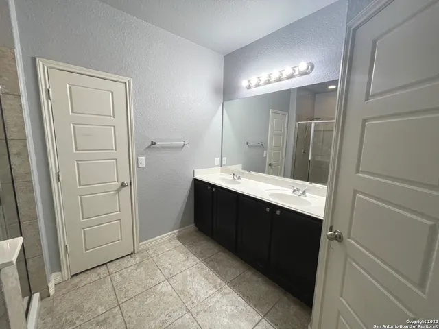 a bathroom with a double vanity sink and mirror