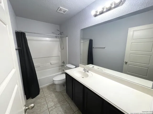 a bathroom with a sink a toilet a mirror and shower