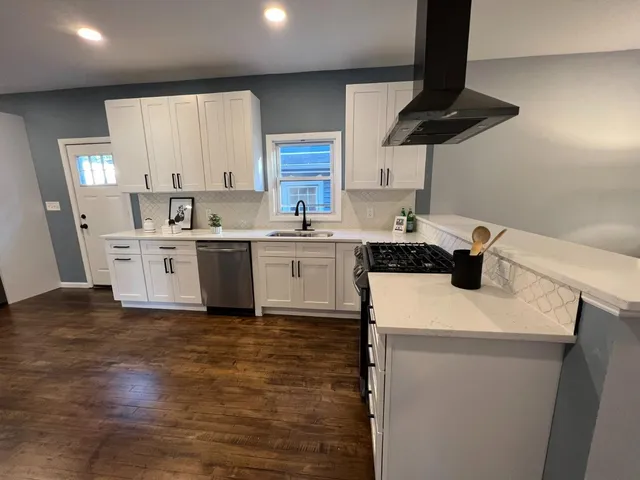 a kitchen with a sink a stove and cabinets