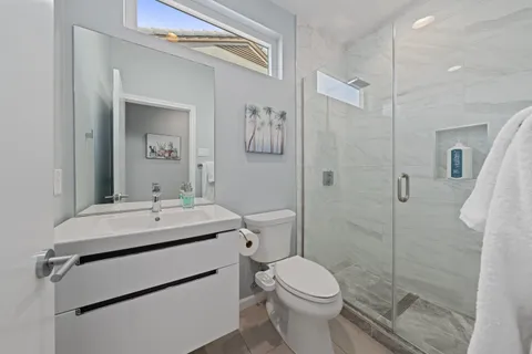 a bathroom with a sink a toilet and shower