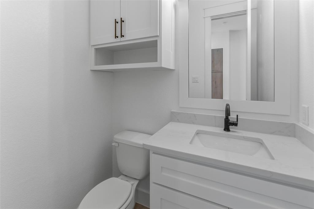 1038 Deer Island Azle, TX 76020 - Photo 16 of 32 a bathroom with a toilet sink and mirror