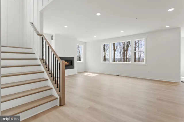a view of a hallway with wooden floor and windows