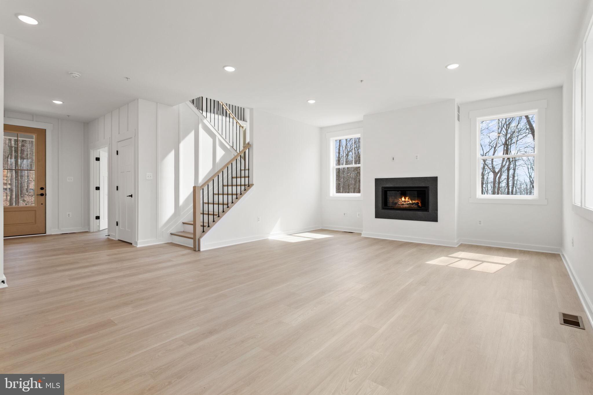 6512 Shady Side Road Shady Side, MD 20764 - Photo 15 of 29 an empty room with wooden floor fireplace and windows