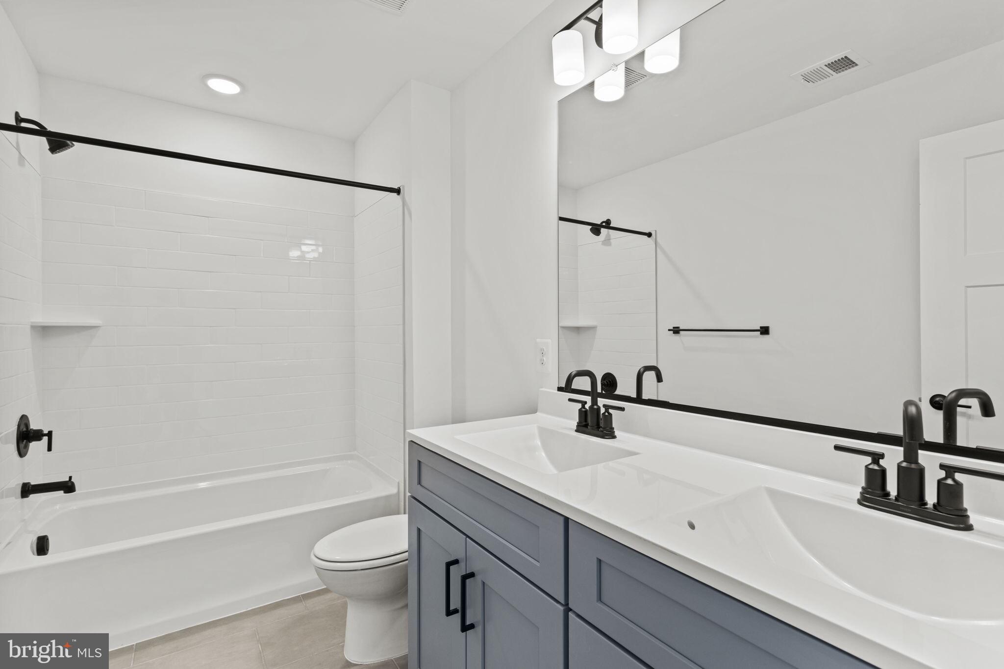 6512 Shady Side Road Shady Side, MD 20764 - Photo 20 of 29 a bathroom with a sink a toilet a mirror a bathtub and shower