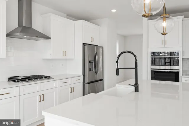 a kitchen with kitchen island stainless steel appliances a stove a sink refrigerator and cabinets