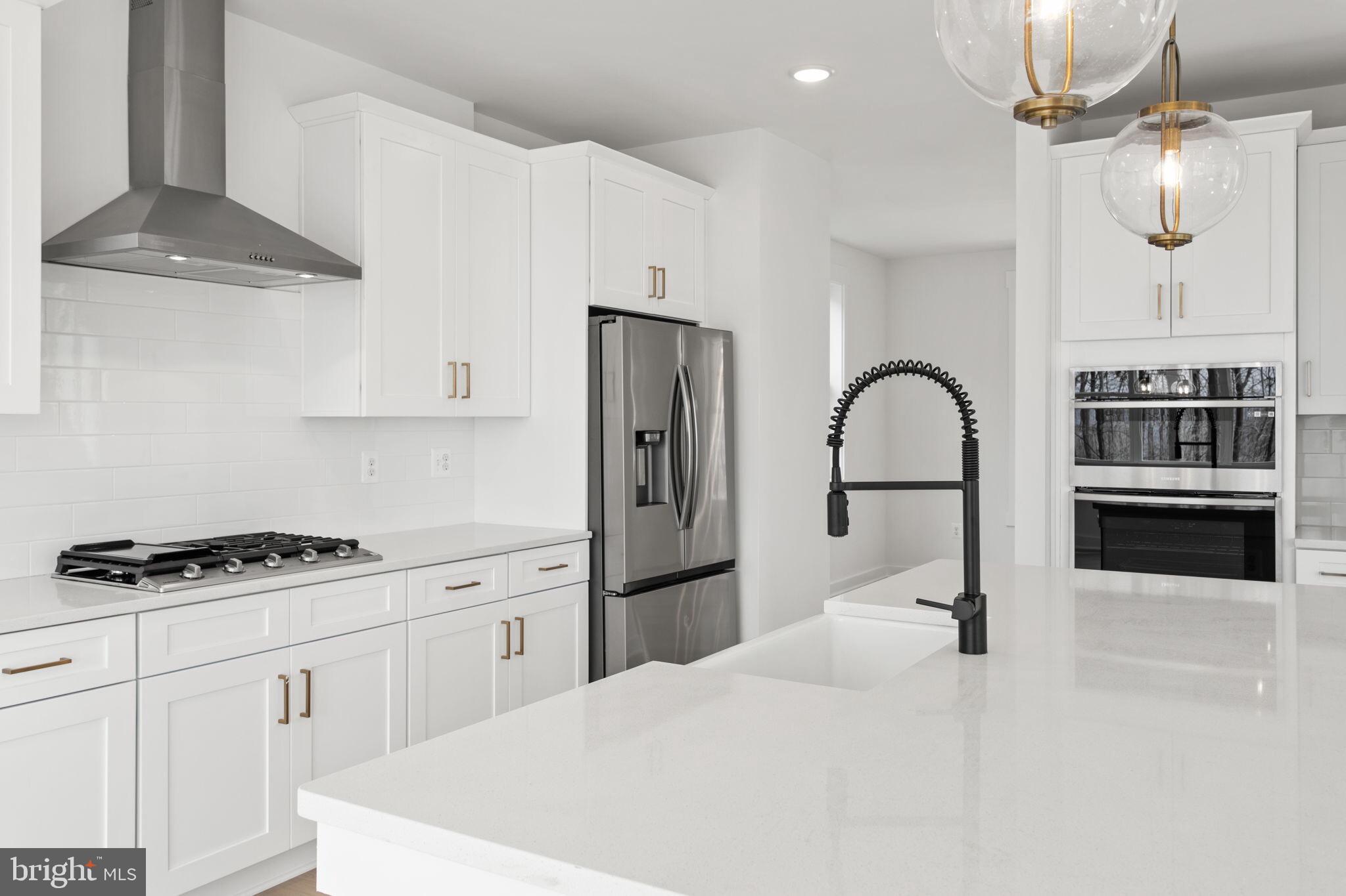 6512 Shady Side Road Shady Side, MD 20764 - Photo 4 of 29 a kitchen with kitchen island stainless steel appliances a stove a sink refrigerator and cabinets