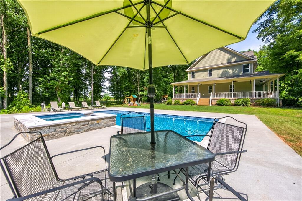 632 Geiger Road Jefferson, GA 30549 - Photo 44 of 55 a patio with a table and chairs under an umbrella