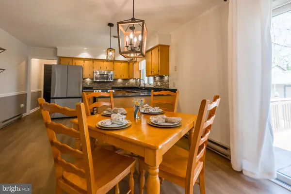 a view of a dining room with furniture a chandelier and wooden floor