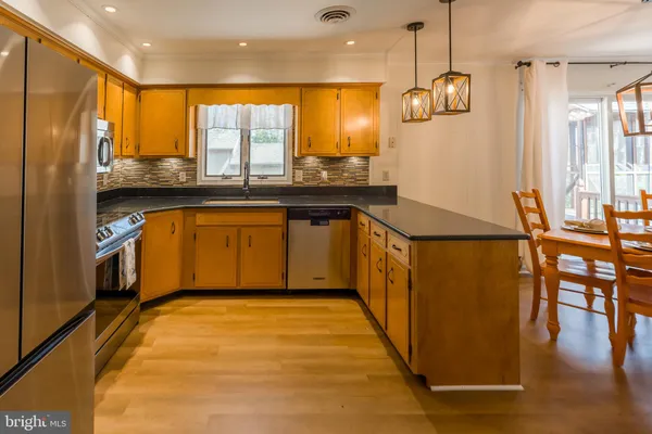 a kitchen with stainless steel appliances granite countertop a refrigerator a sink and a stove