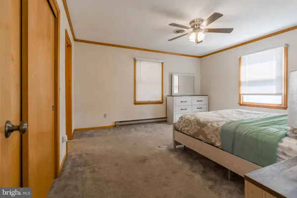a spacious bedroom with a large bed and a chandelier