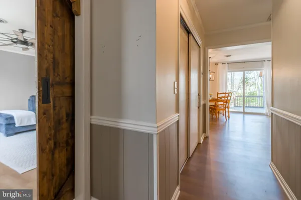 a view of a hallway with wooden floor and furniture