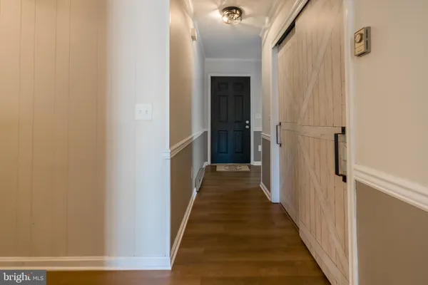 a view of a hallway with wooden floor and staircase