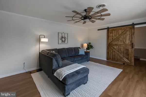 a living room with furniture and a wooden floor