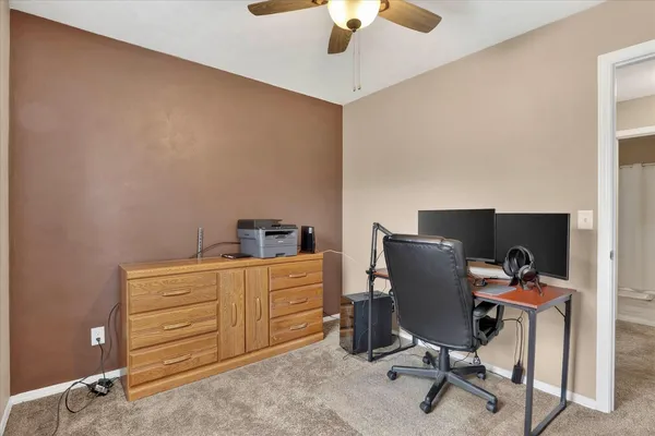 an empty room with windows and fireplace
