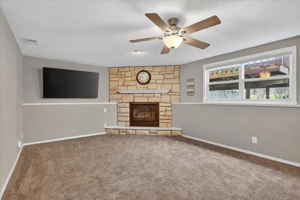 an empty room with fireplace and fan