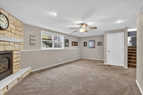 a view of an empty room with window and ceiling fan