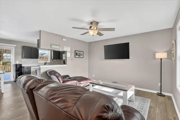 a kitchen with granite countertop a stove a microwave a refrigerator a sink dishwasher with a dining table and chairs