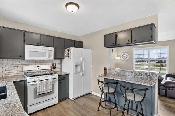 a kitchen with stainless steel appliances granite countertop a stove sink and refrigerator