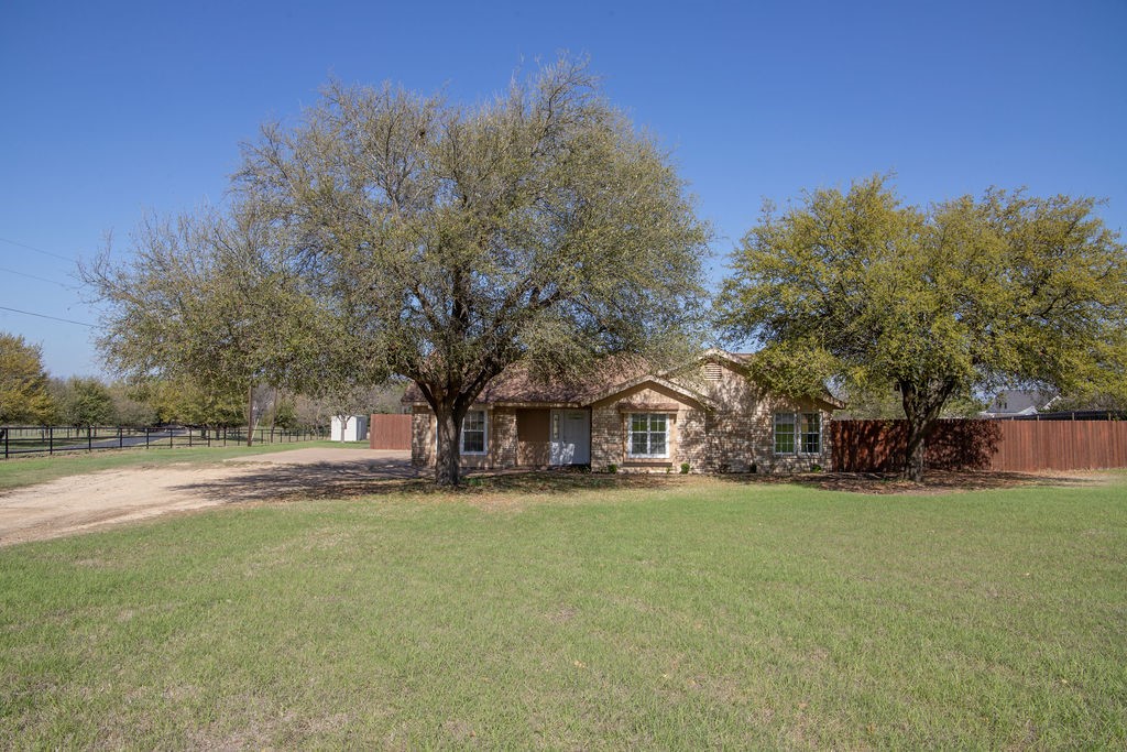 a view of a yard with a house in the background