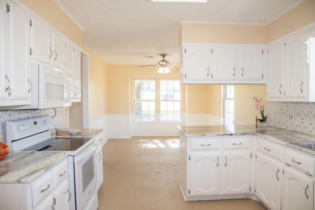 261 Rabbit Hill Lorena, TX 76655 - Photo 17 of 50 a kitchen with granite countertop white cabinets and white appliances