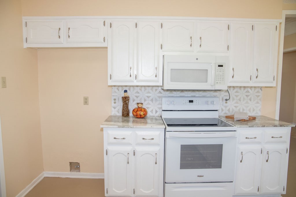 261 Rabbit Hill Lorena, TX 76655 - Photo 18 of 50 a kitchen with granite countertop white cabinets and white appliances