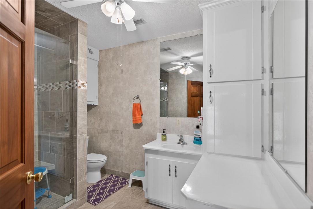 145 State Rd S-4-935 Pendleton, SC 29670 - Photo 13 of 47 A well-appointed bathroom features a glass-enclosed shower with tiled walls and a vanity with ample storage.