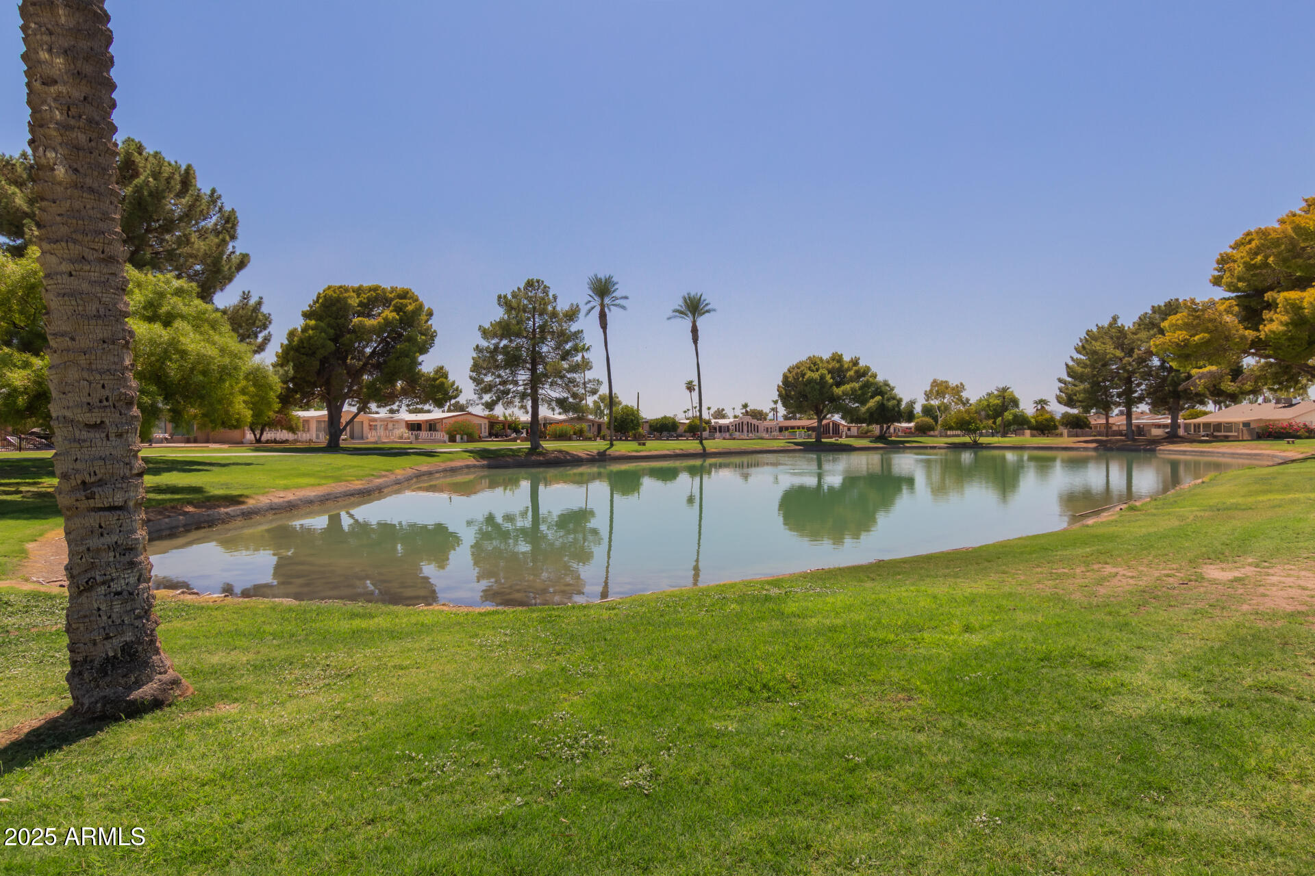 8883 East Fairway Boulevard Sun Lakes, AZ 85248 - Photo 27 of 30 a view of a lake with houses in the background