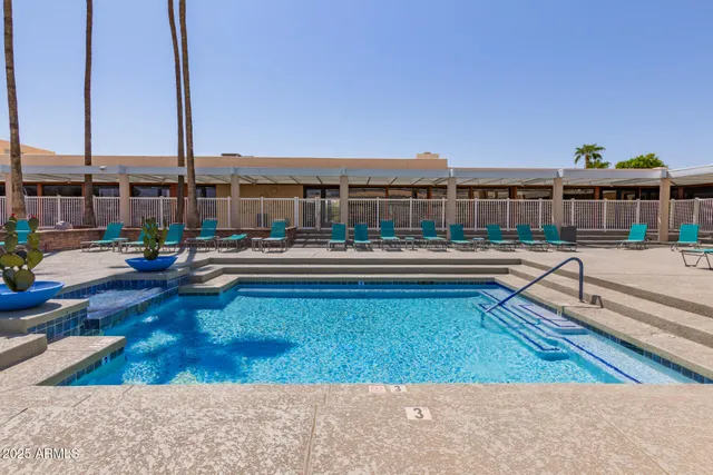 a swimming pool view with a seating space