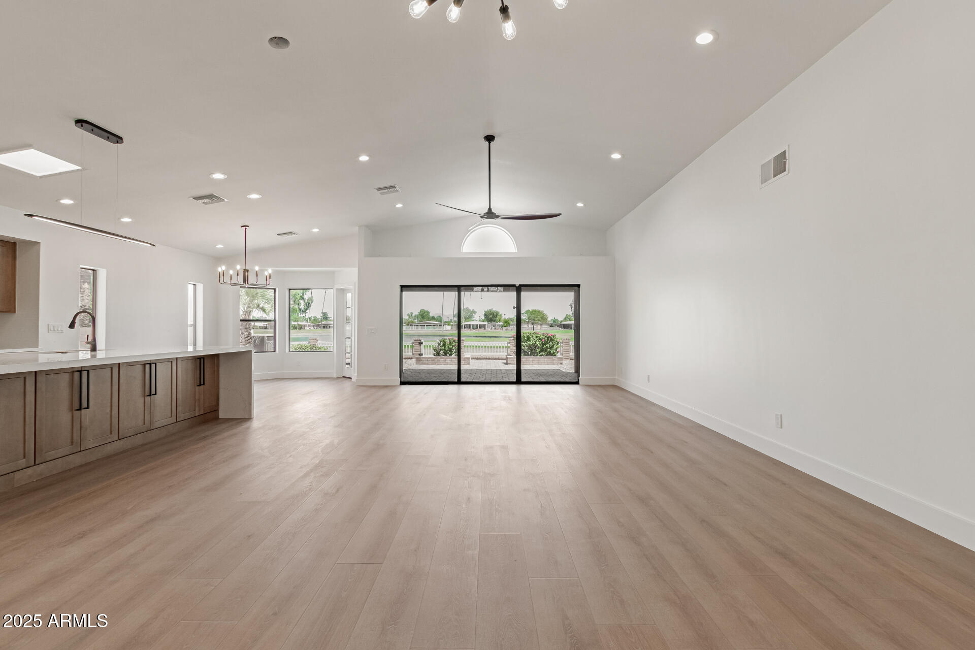 8883 East Fairway Boulevard Sun Lakes, AZ 85248 - Photo 4 of 30 a view of an empty room with wooden floor kitchen view and a window