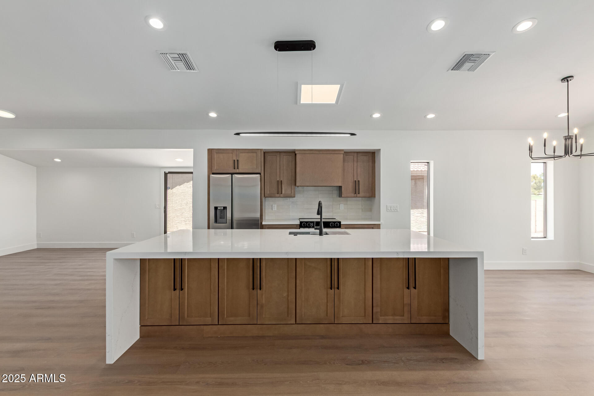 8883 East Fairway Boulevard Sun Lakes, AZ 85248 - Photo 5 of 30 a large white kitchen with kitchen island a sink stainless steel appliances and cabinets