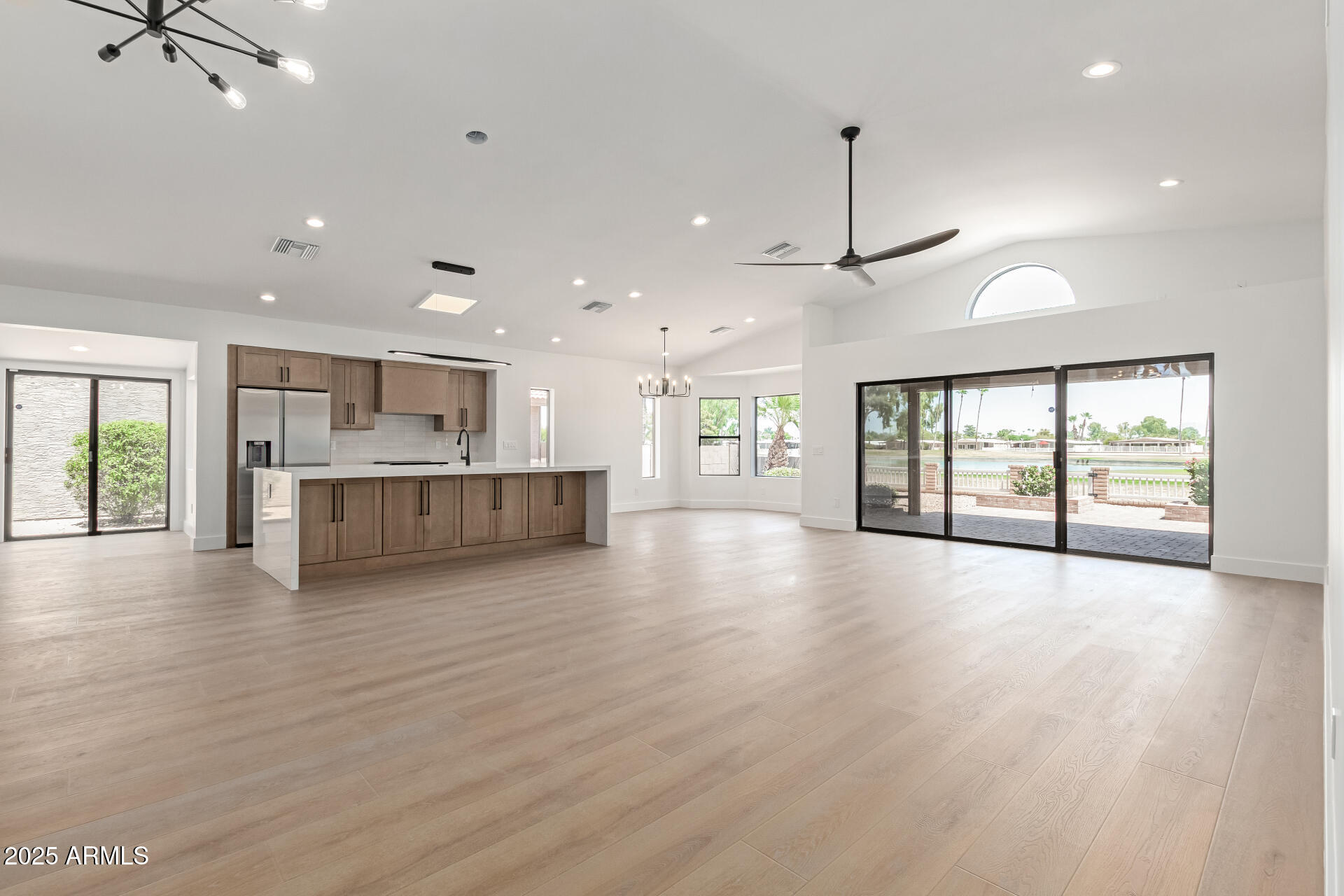 8883 East Fairway Boulevard Sun Lakes, AZ 85248 - Photo 6 of 30 a view of an empty room with wooden floor and a kitchen