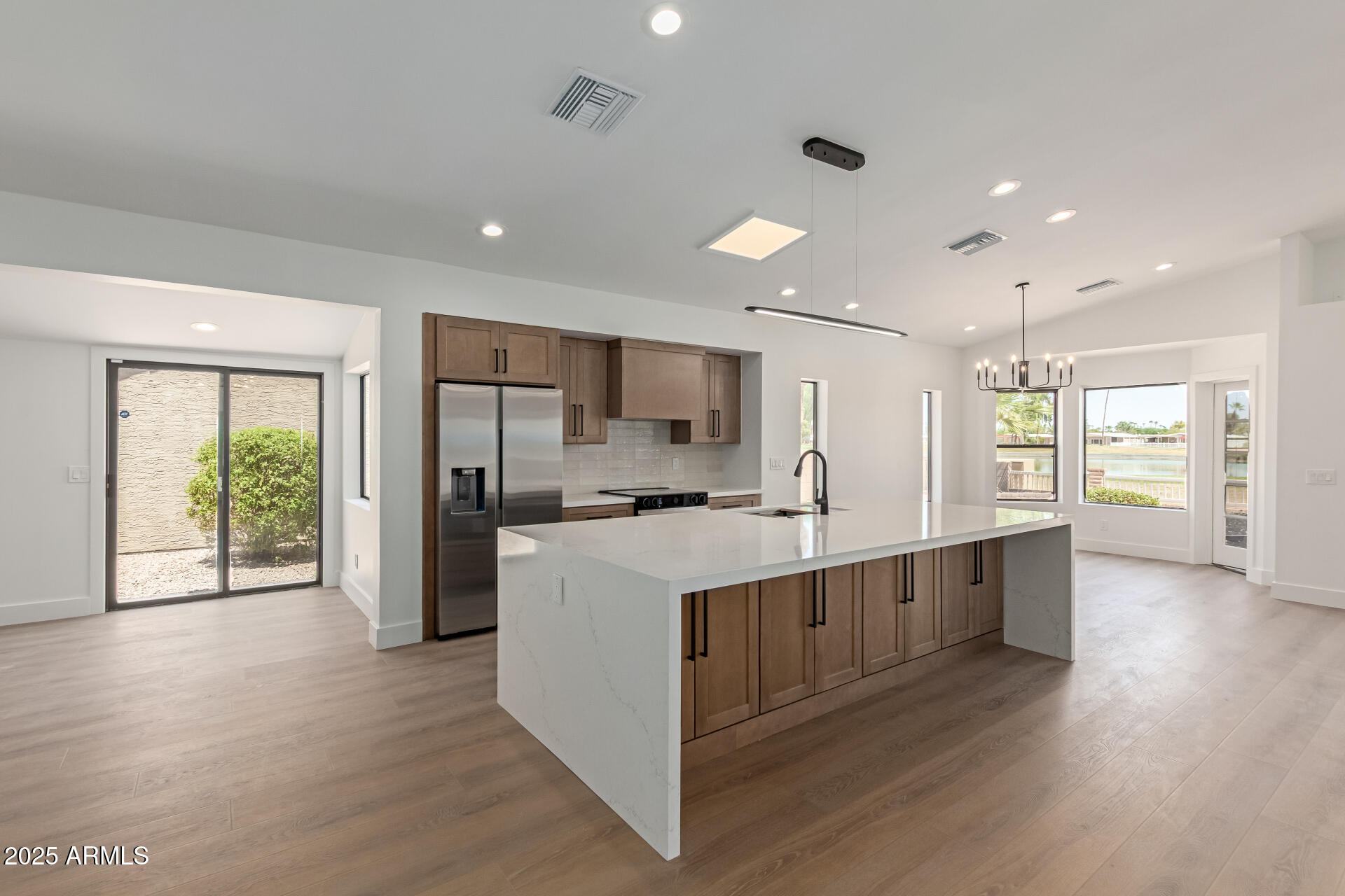 8883 East Fairway Boulevard Sun Lakes, AZ 85248 - Photo 7 of 30 a large kitchen with stainless steel appliances a large counter top a sink a refrigerator and a window