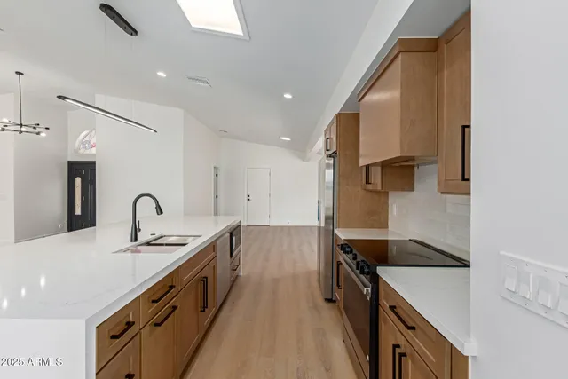 a kitchen with granite countertop a sink stove and cabinets