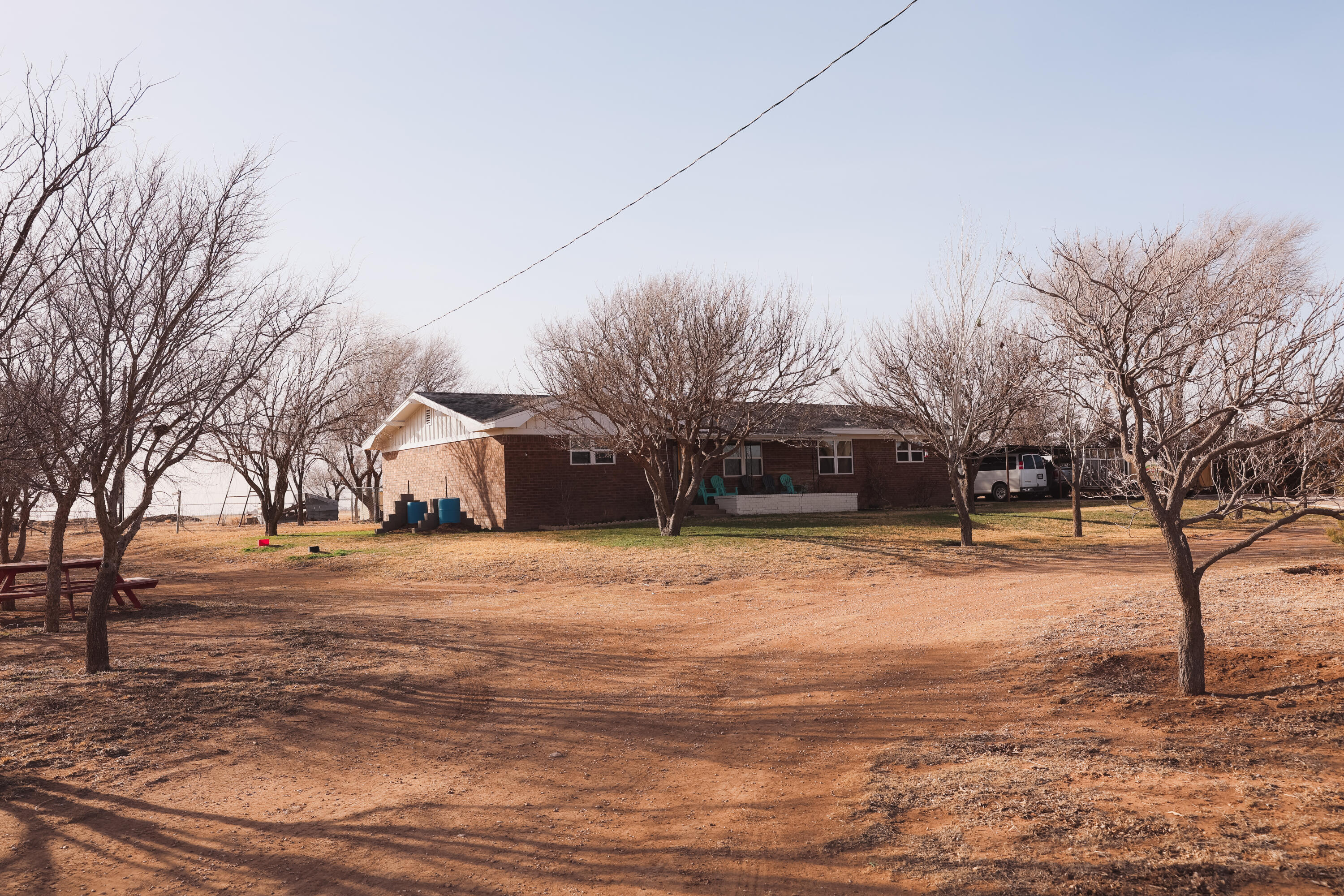 660 County Road K Plainview, TX 79072 - Photo 2 of 66 a yellow house with trees in the background