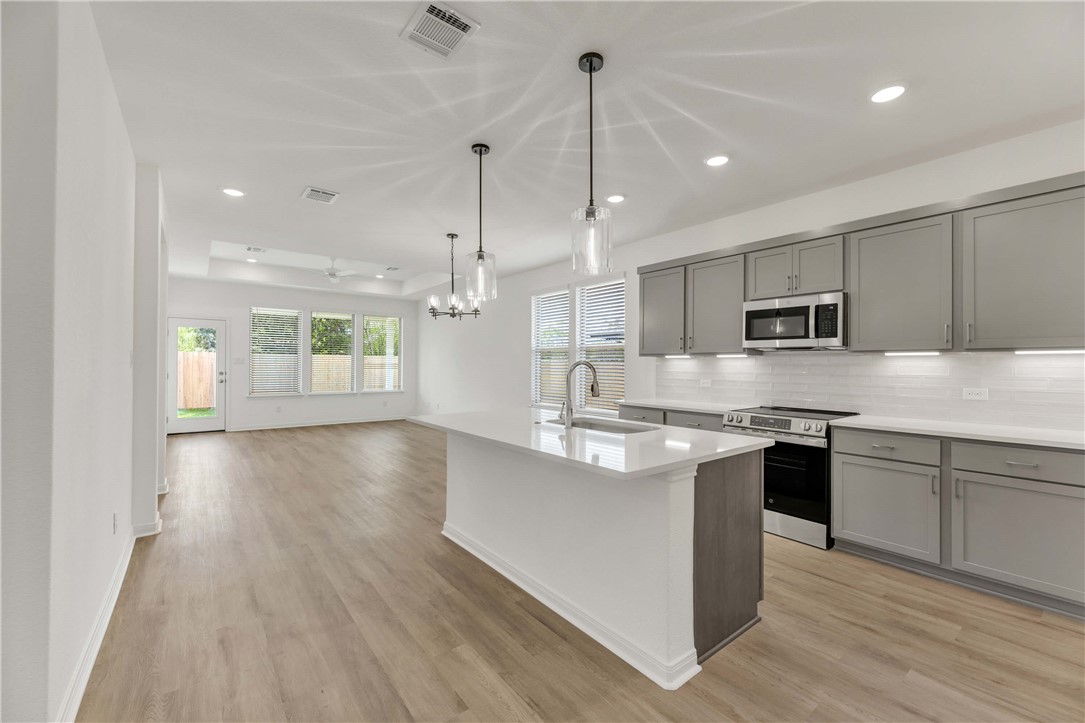 2776 Messenger Way Bryan, TX 77803 - Photo 3 of 16 a kitchen with stainless steel appliances granite countertop a sink a stove and a wooden floors