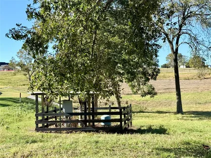 a view of a yard with wooden fence