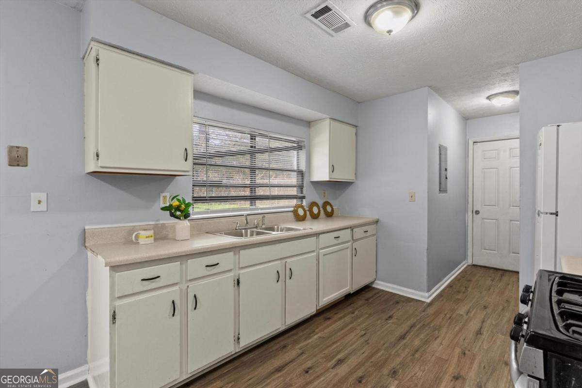 8877 Burnham Way Jonesboro, GA 30238 - Photo 11 of 23 a kitchen with sink cabinets and wooden floor