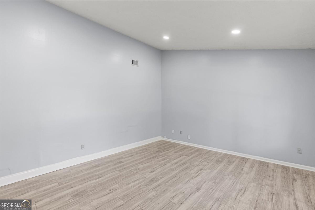 8877 Burnham Way Jonesboro, GA 30238 - Photo 4 of 23 a view of room with wooden floor and fan