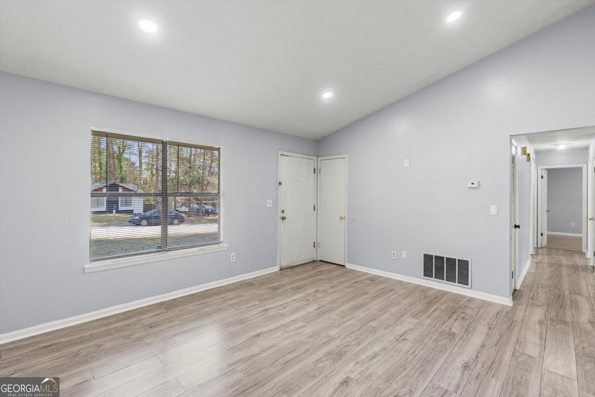 8877 Burnham Way Jonesboro, GA 30238 - Photo 6 of 23 an empty room with wooden floor and windows
