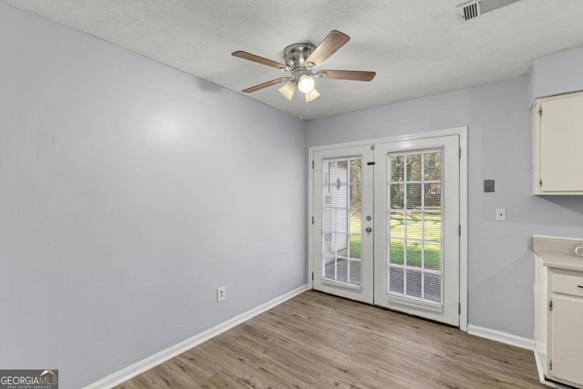 8877 Burnham Way Jonesboro, GA 30238 - Photo 7 of 23 a view of an empty room with wooden floor and a window