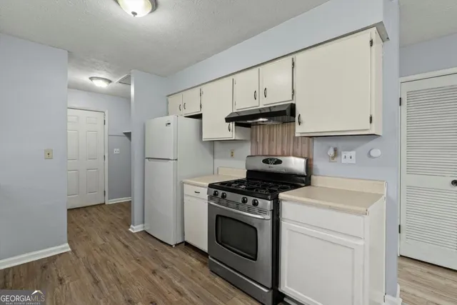 a kitchen with a stove a refrigerator and a sink