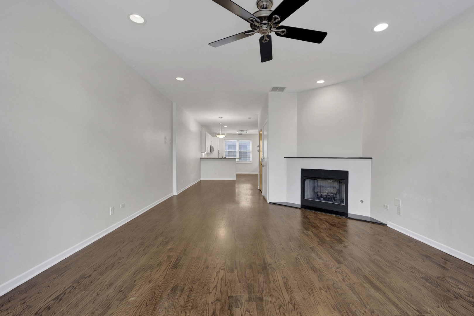 1812 South State Street, Unit 3 Chicago, IL 60616 - Photo 6 of 29 an empty room with wooden floor a fireplace and windows