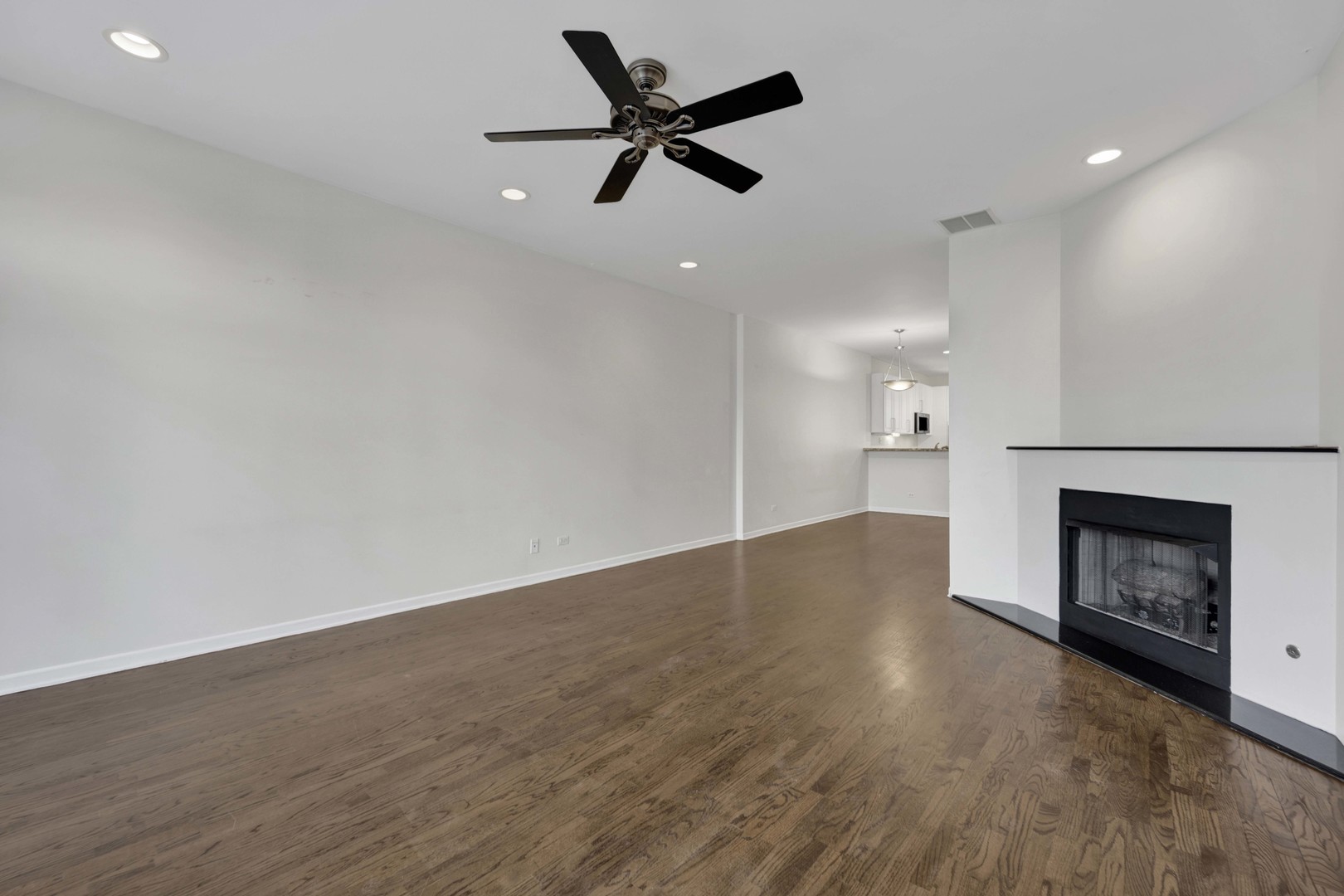 1812 South State Street, Unit 3 Chicago, IL 60616 - Photo 7 of 29 wooden floor in an empty room with a fireplace and a ceiling fan