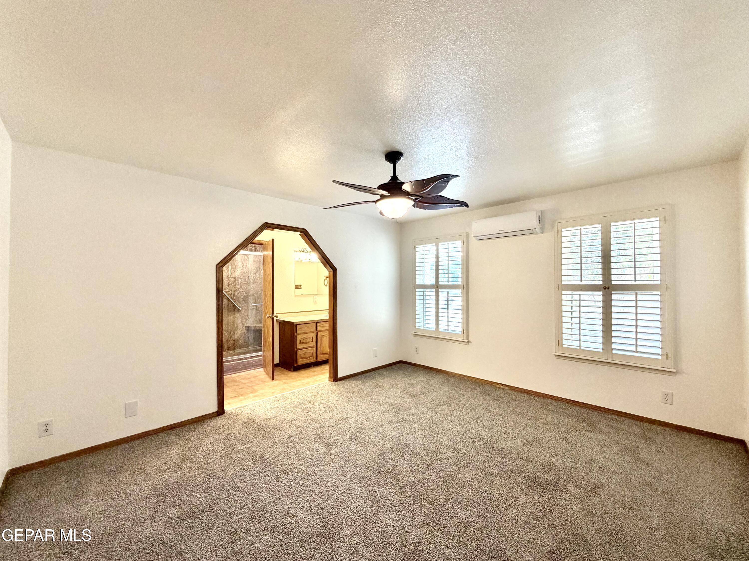 2452 West Ohara Road Anthony, NM 88021 - Photo 14 of 56 an empty room with chandelier fan and windows