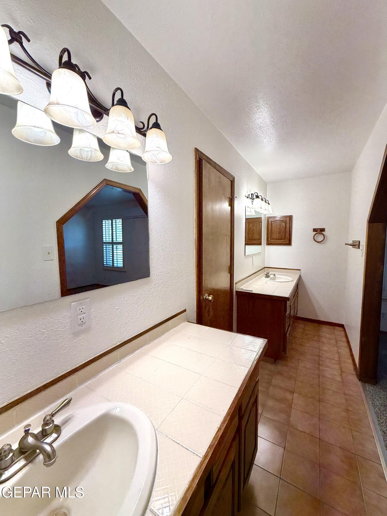 2452 West Ohara Road Anthony, NM 88021 - Photo 18 of 56 a kitchen with stainless steel appliances kitchen island a chandelier