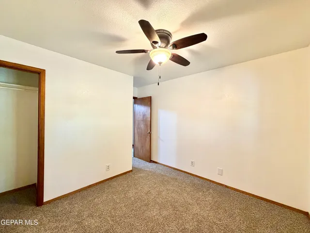 a view of empty room with wooden floor and fireplace