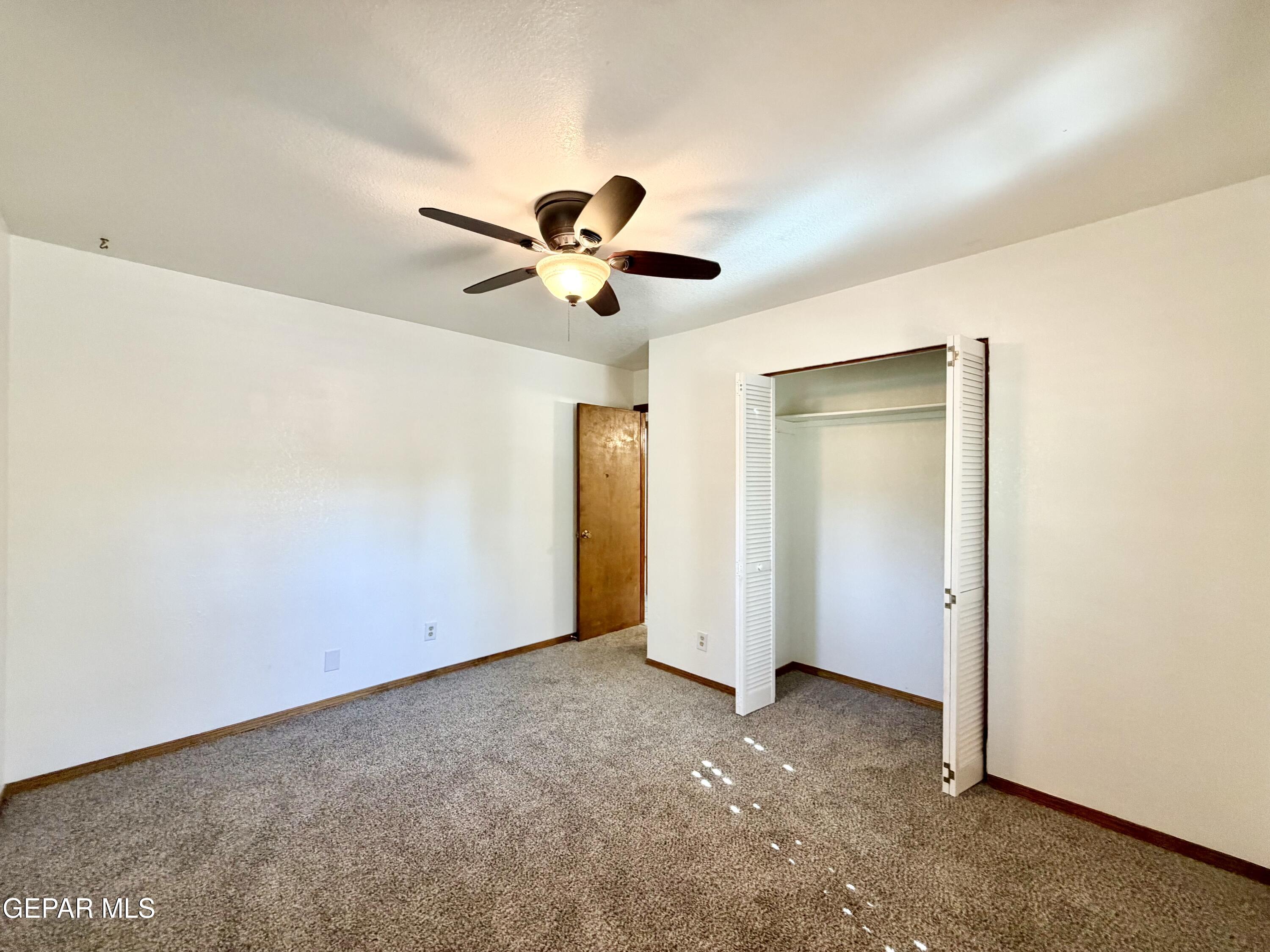 2452 West Ohara Road Anthony, NM 88021 - Photo 26 of 56 an empty room with a ceiling fan and a window