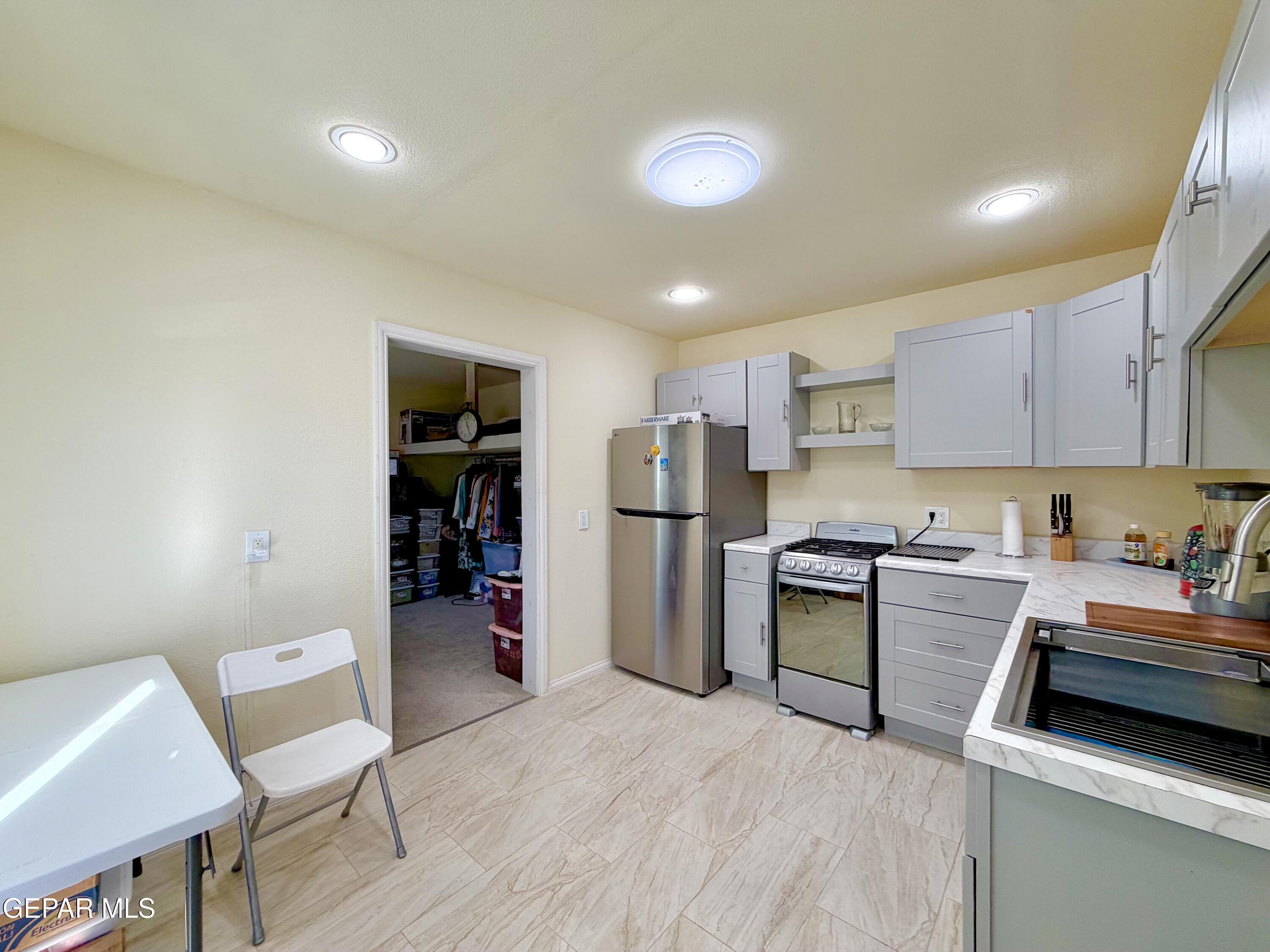2452 West Ohara Road Anthony, NM 88021 - Photo 37 of 56 a kitchen with a refrigerator and a stove top oven